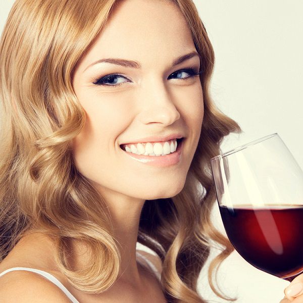 woman with beautiful skin drinking glass of red wine